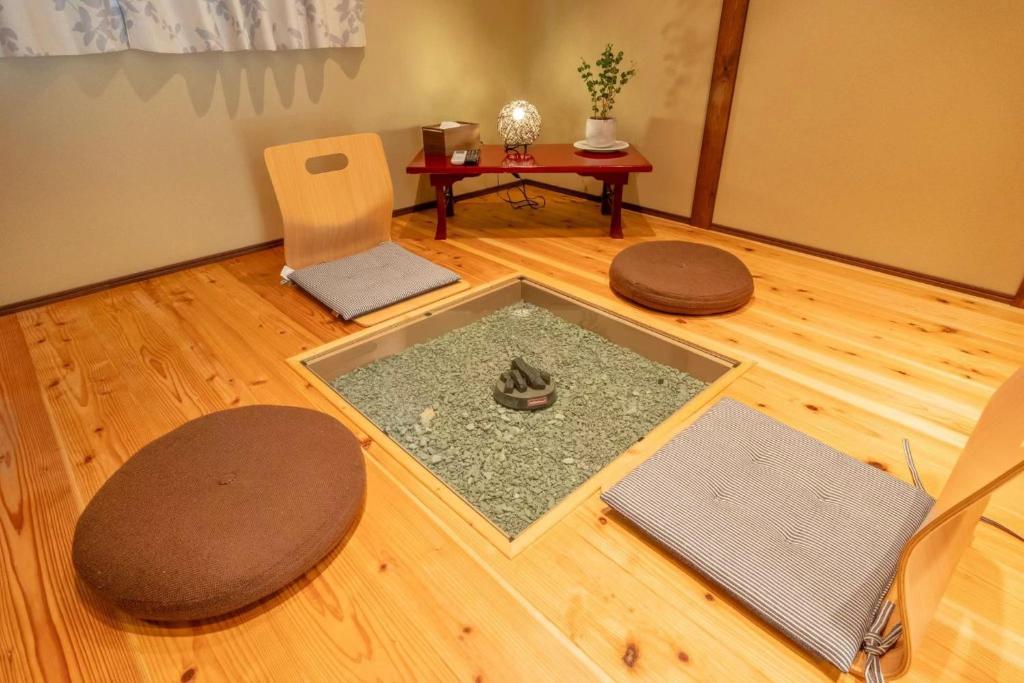 a living room with a table and chairs and a floor at 三十三Tuchi in Kyoto