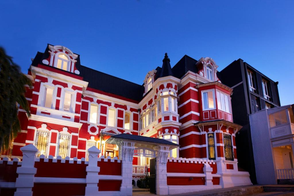 Palacio Astoreca في فالبارايسو: مبنى احمر كبير بسقف اسود