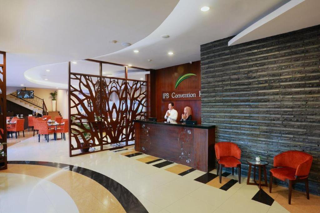 a lobby of a restaurant with a counter and chairs at IPB Convention Hotel Botani Square in Bogor
