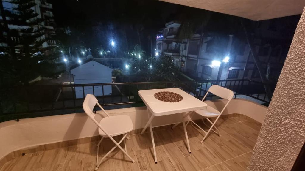 a table and chairs on a balcony at night at 2bhk apartment baga with kitchen in North goa