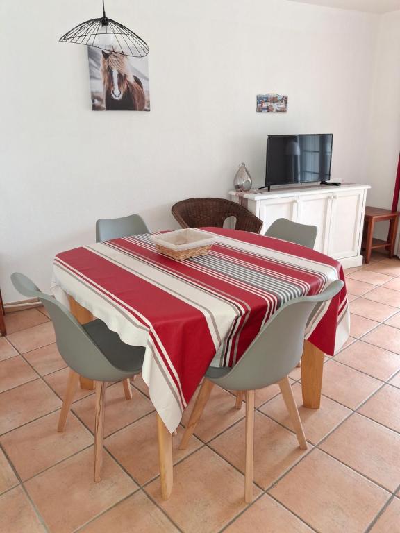 une table à manger avec un tissu de table rouge et blanc rayé dans l'établissement Appartement Entre terre et mer 4 personnes, à Uhart-Cize