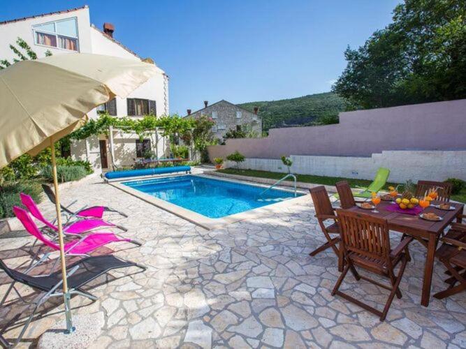 a patio with a table and chairs and a pool at Villa Roza - Studio Apartment with Balcony in Mokošica