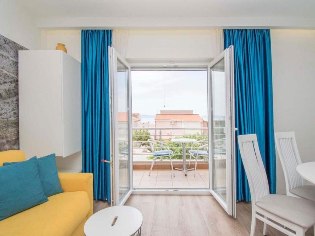 a living room with a yellow couch and a sliding glass door at Apartments Antonio - Comfort One-Bedroom Apartment with Balcony and Sea View - 4 in Tučepi