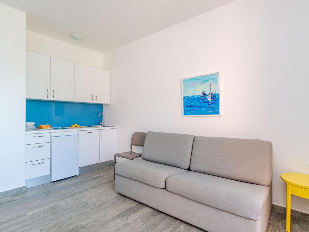 Una sala de estar con un sofá y una cocina. en Apartments Villa Lukas - ''No 4'' One-Bedroom Apartment with Balcony and Sea View, en Cavtat