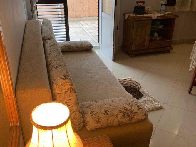 a couch sitting in a living room next to a lamp at Apartments Nives - Three Bedroom Apartment with Terrace and Sea View in Smokvica