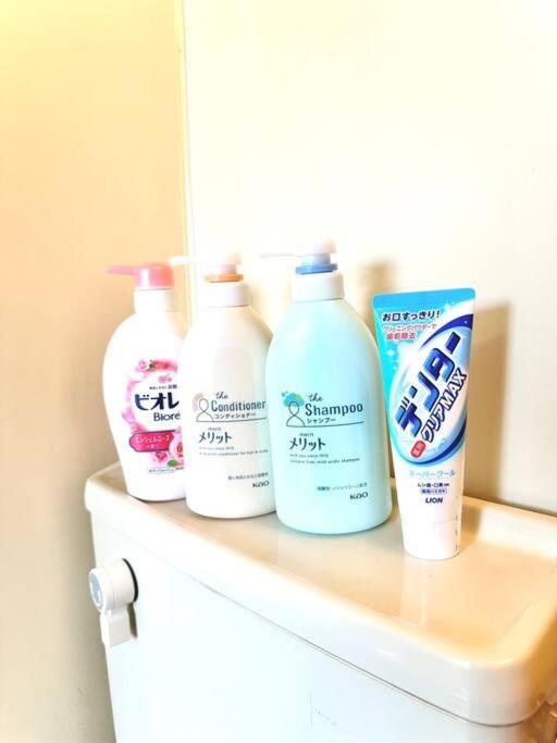 four bottles of cleaning products sitting on top of a shelf at 301号室駅2分格安和室民泊専用ミニキッチンとバスルーム付きアクセス抜群 in Osaka