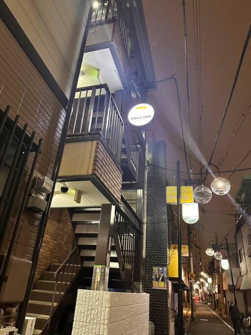 a building with a spiral staircase in a street at 301号室駅2分格安和室民泊専用ミニキッチンとバスルーム付きアクセス抜群 in Osaka