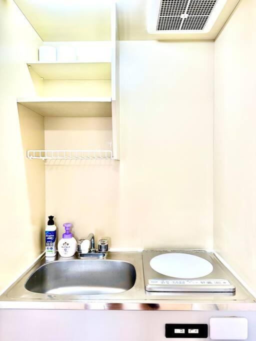 a bathroom with a sink and a mirror at 301号室駅2分格安和室民泊専用ミニキッチンとバスルーム付きアクセス抜群 in Osaka