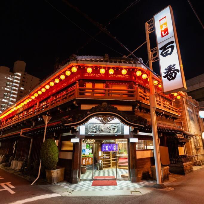 a building with a sign in front of it at 301号室駅2分格安和室民泊専用ミニキッチンとバスルーム付きアクセス抜群 in Osaka