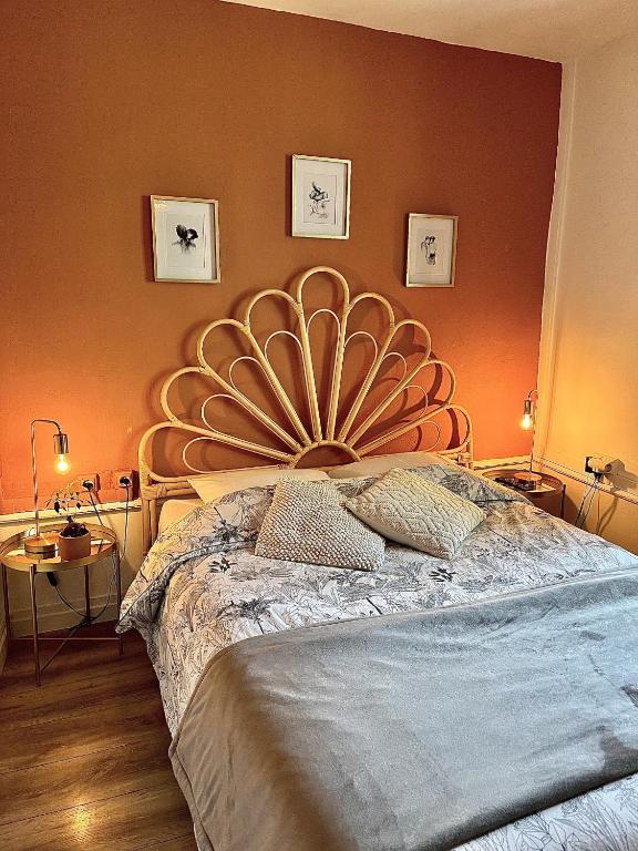 - une chambre avec un lit doté d'une grande tête de lit dans l'établissement Charmant logement & terrasse au centre historique, à Saint-Claude