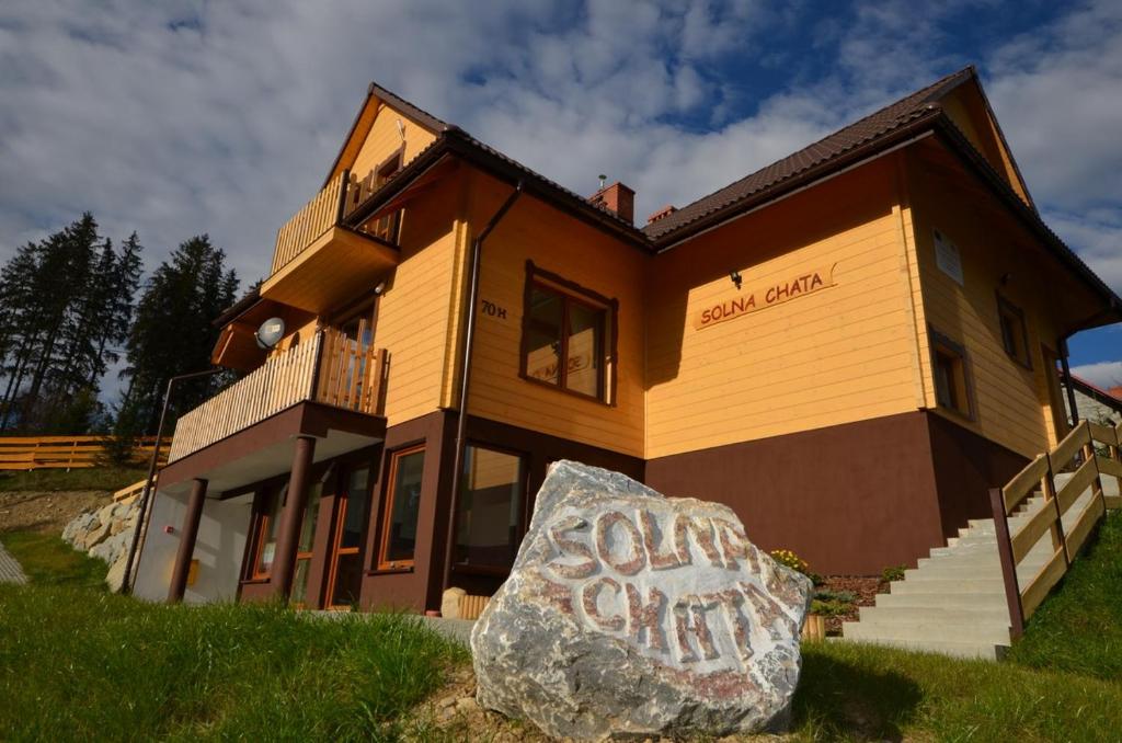 a house with a large rock in front of it at Solna Chata-dom na wyłączność Grota solna, balia, sauna, basen in Rajcza