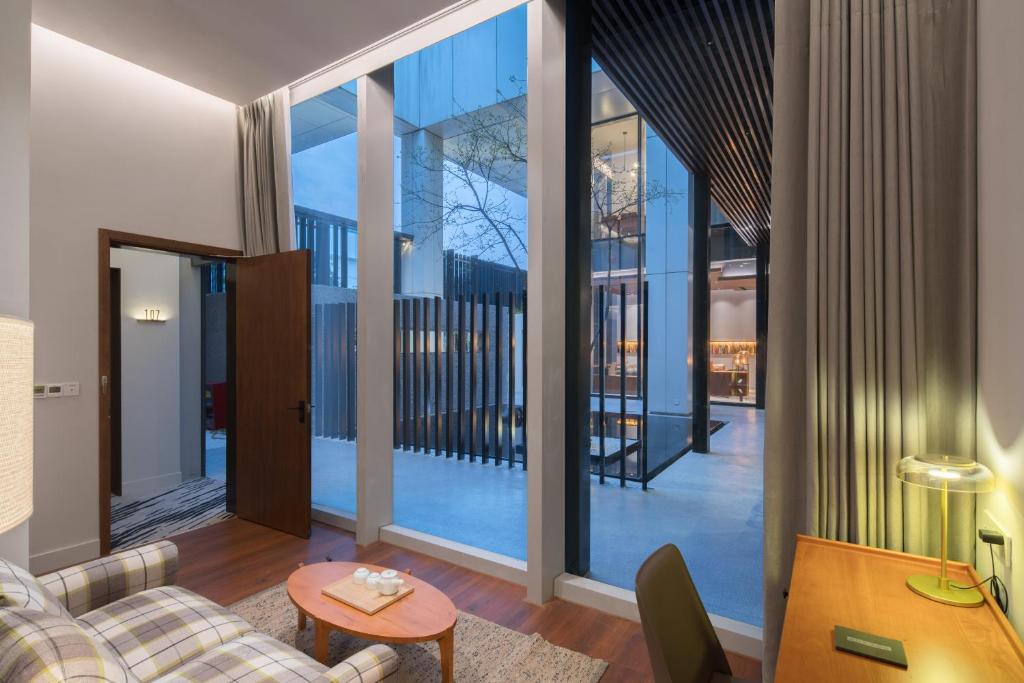 un soggiorno con un divano e un tavolo di Wuyu Hotel Chongqing Zoo & Yangjiaping The Mixc Light rail a Chongqing