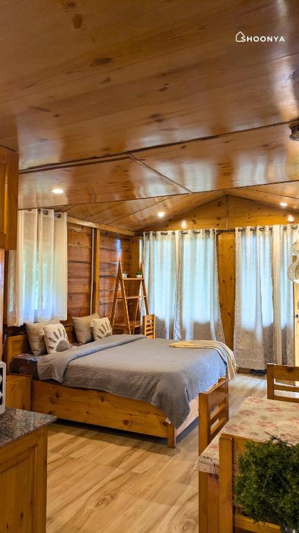 a bedroom with a large bed in a log cabin at Shoonya Mukteshwar in Mukteswar
