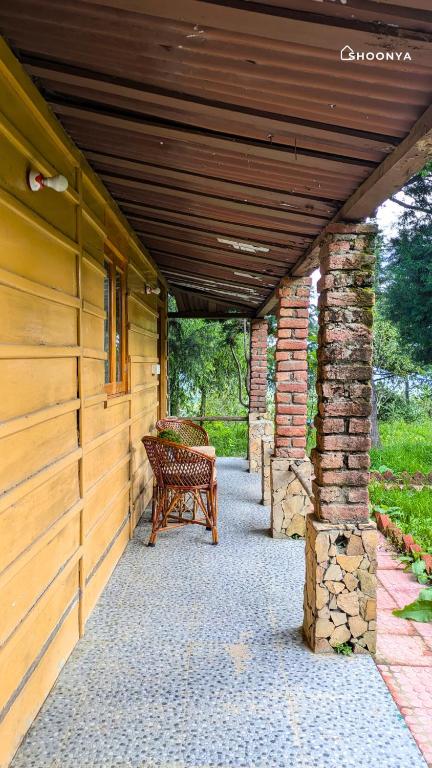 a porch with a bench on the side of a house at Shoonya Mukteshwar in Mukteswar