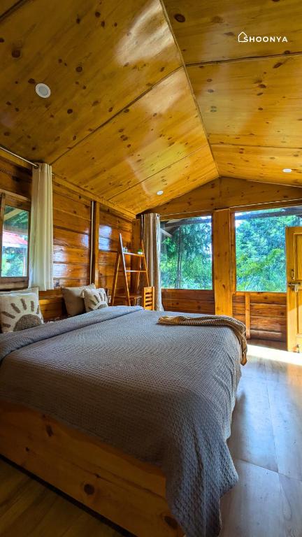 a bedroom with a bed in a wooden cabin at Shoonya Mukteshwar in Mukteswar