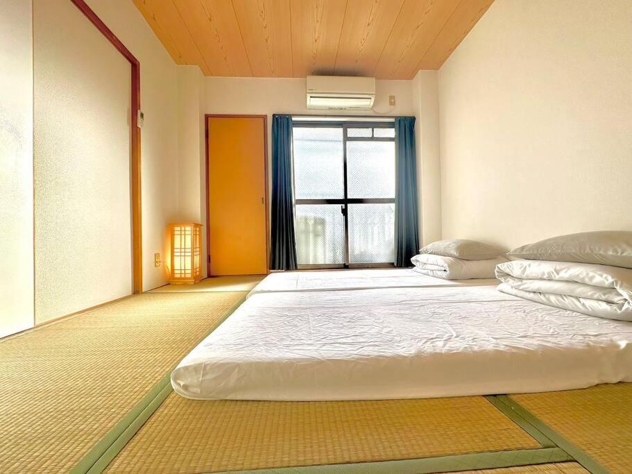 大阪市にある303号室南海線駅2分の明るい和室専用キッチンとバスルーム付き荷物預りの大きな窓のある部屋にある大きなベッド