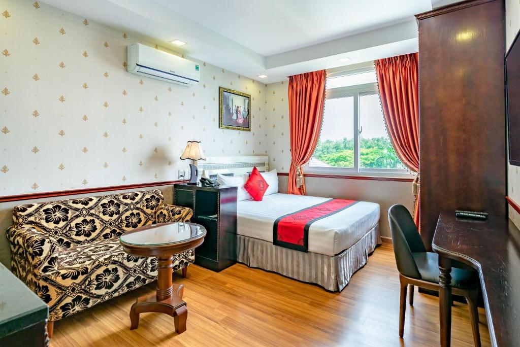 a hotel room with a bed and a couch at Collection O Emerald Luxury Apartment - Near SECC in Ho Chi Minh City