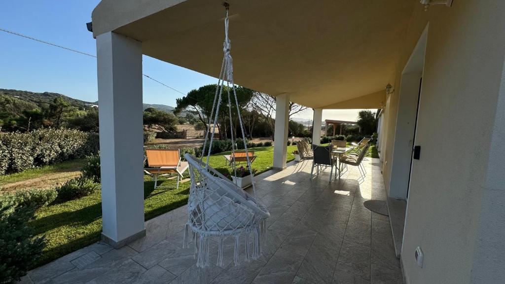 a porch of a house with chairs and a swing at Appartamento i Pini in Palau