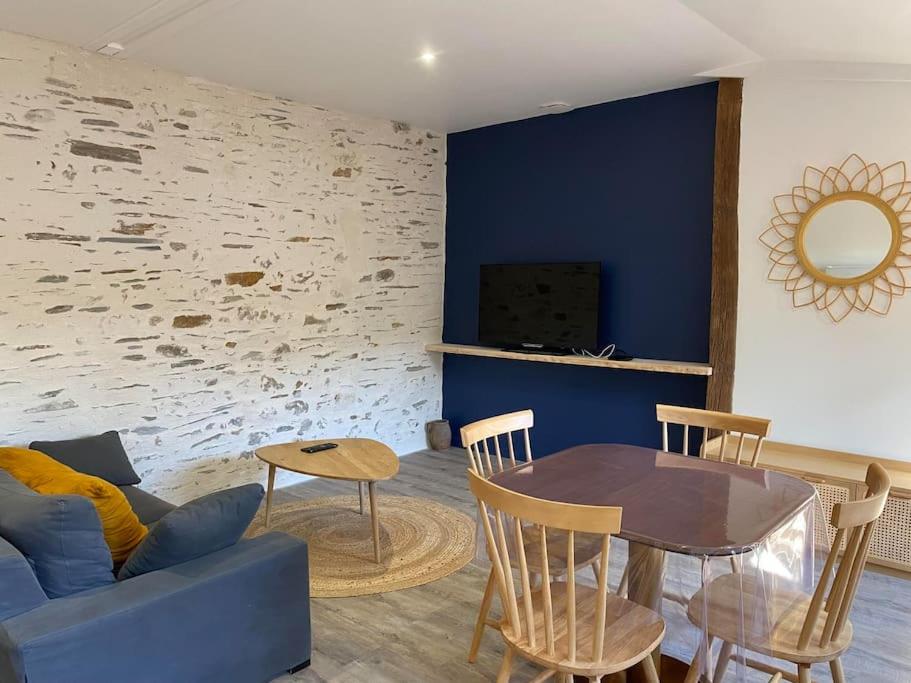 un salon avec un canapé bleu et une table dans l'établissement Maison - Brissac Quincé Centre, à Brissac-Quincé