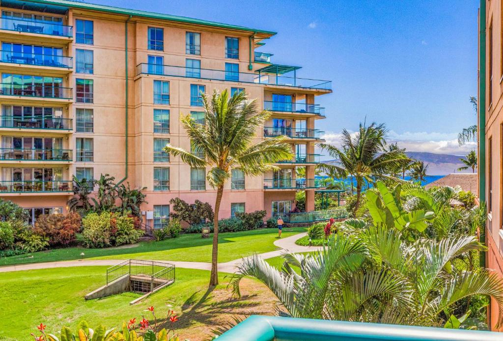 a view of a large apartment building with palm trees at Honua Kai Konea 204 in Kahana