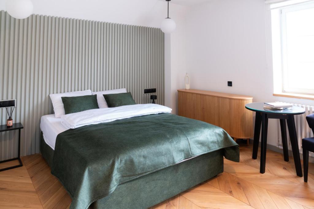 a bedroom with a bed with a green blanket at Grodzka Stare Miasto Aparthotel - Dream Apart in Jelenia Góra