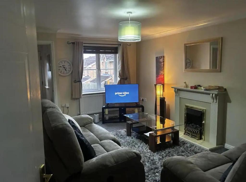 a living room with a couch and a television at Brades Rise Retreat - Cozy 3 Bedroom House in Oldbury