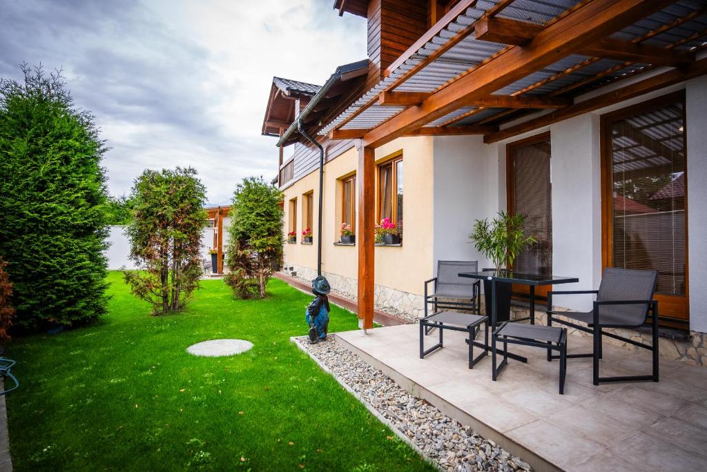 a patio with a table and chairs in a yard at Apartmány Alexiss in Liptovský Mikuláš