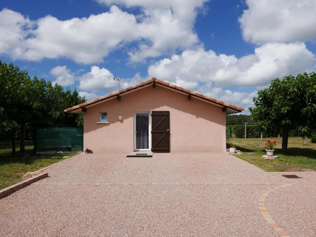 a small pink house on a gravel driveway at La sauvagine in Soustons