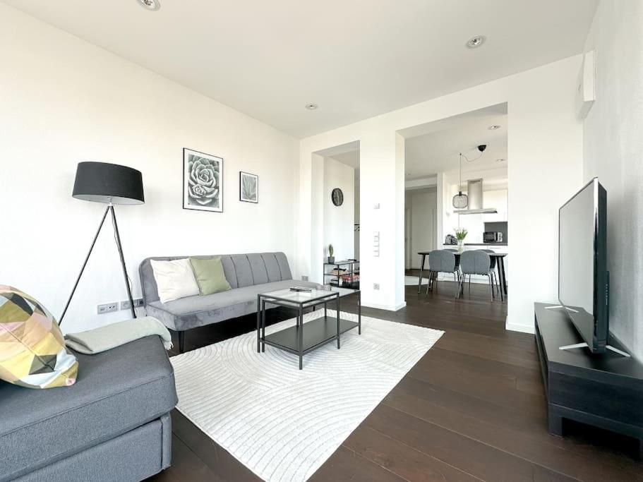 CityLoft - Augsburger Innenstadt-Bismarckviertel - kostenloser Tiefgaragenstellplatz في اوغسبورغ: غرفة معيشة بها أريكة وطاولة