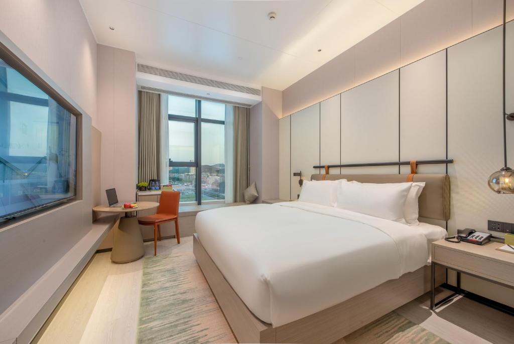 Postel nebo postele na pokoji v ubytování ONESS Executive Hotel Guangzhou Huangpu Luogang