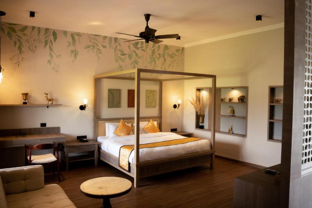 a bedroom with a bed and a desk and a table at Narwar Lakefront Resort in Shivpurī