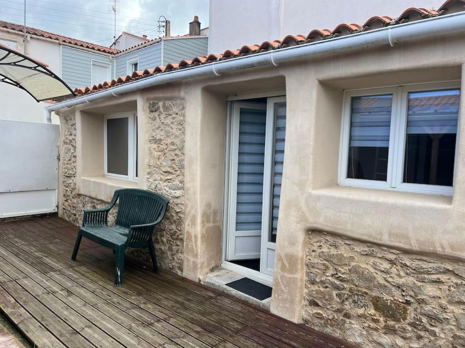 une chaise verte assise sur une terrasse à côté d'un bâtiment dans l'établissement Location Vendée Globe La Chaume, à Les Sables-dʼOlonne