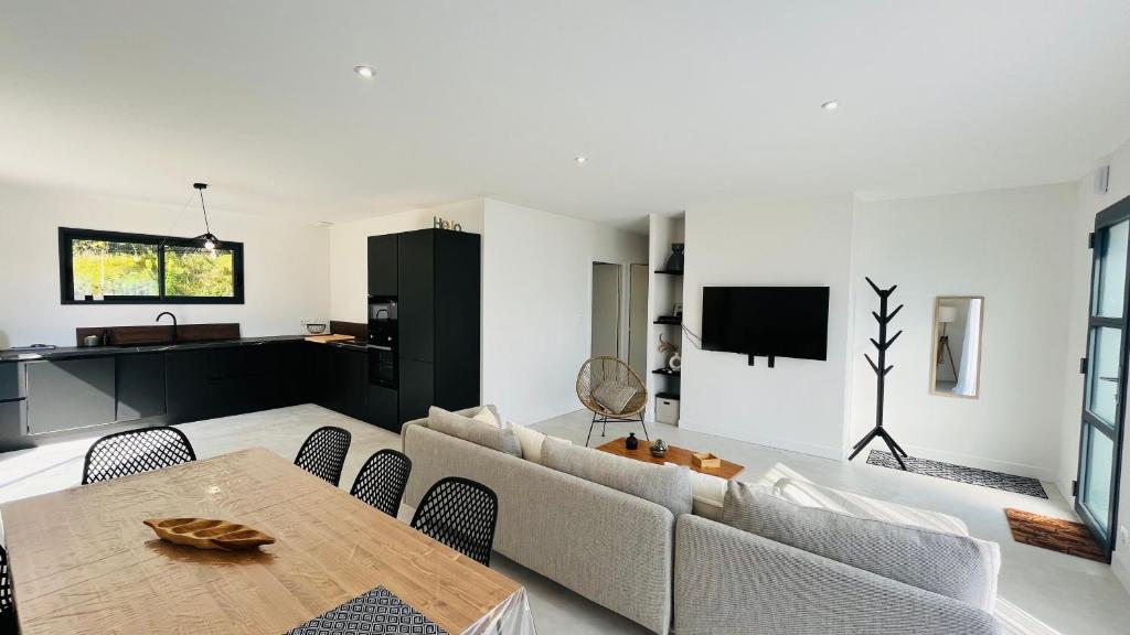 un salon avec un canapé et une table dans l'établissement La Tonka, maison neuve proche océan, à Saint-Jean-de-Monts