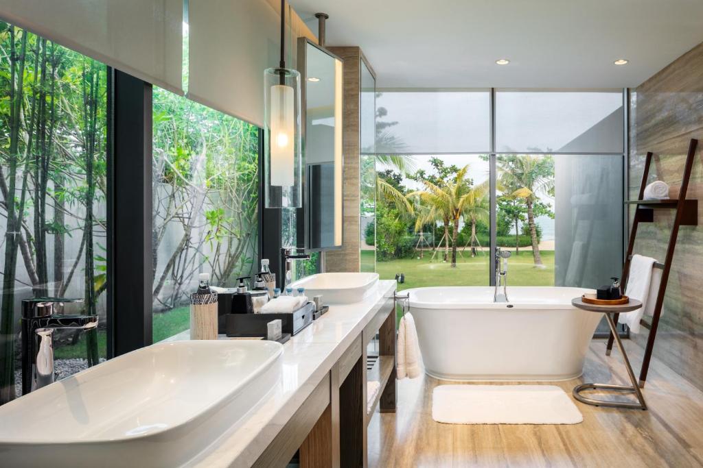 a bathroom with two sinks and a tub and a large window at Anantara Desaru Coast Resort & Villas in Desaru