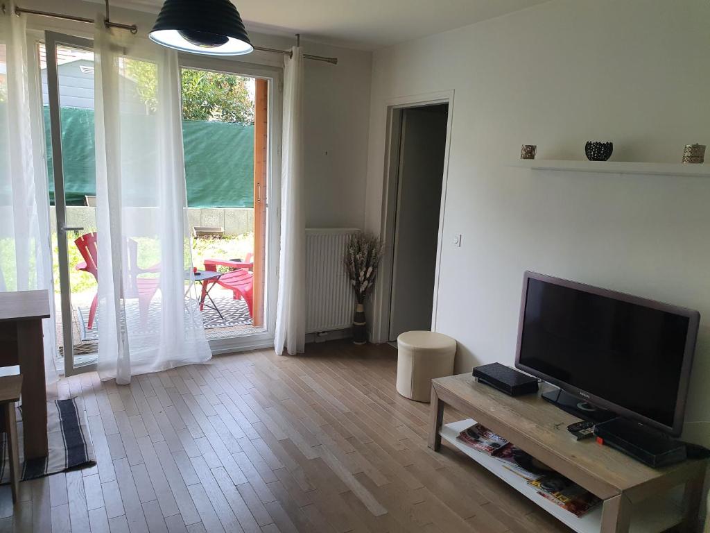 un salon avec une télévision à écran plat sur une table dans l'établissement Appartement Cormeilles, à Cormeilles-en-Parisis