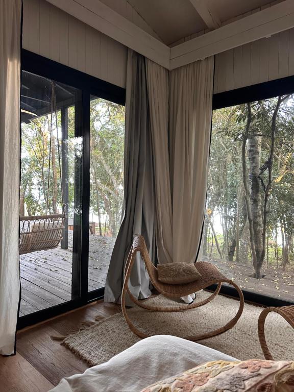 a bedroom with a rocking chair in front of a window at Infinito in Puerto Valle