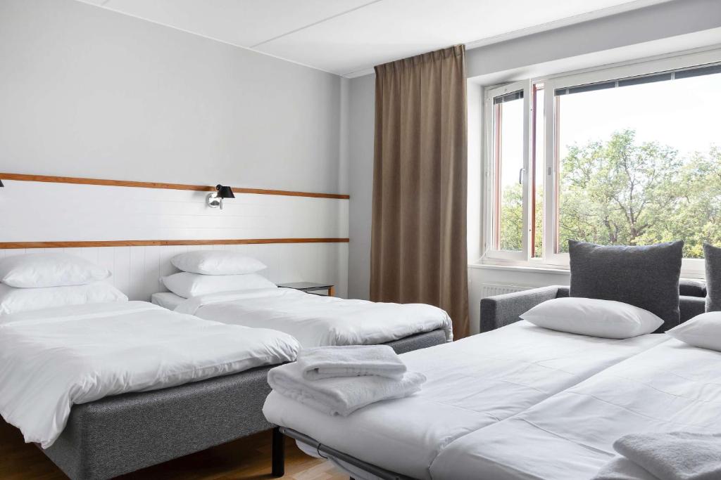 a room with three beds and a window at Best Western Plus Park City Solna in Solna