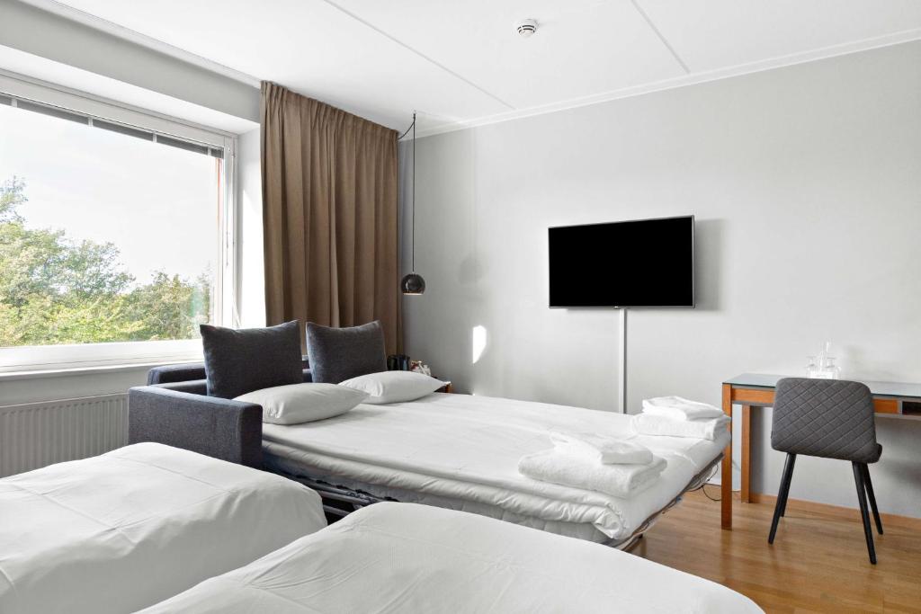 a hotel room with two beds and a tv at Best Western Plus Park City Solna in Solna