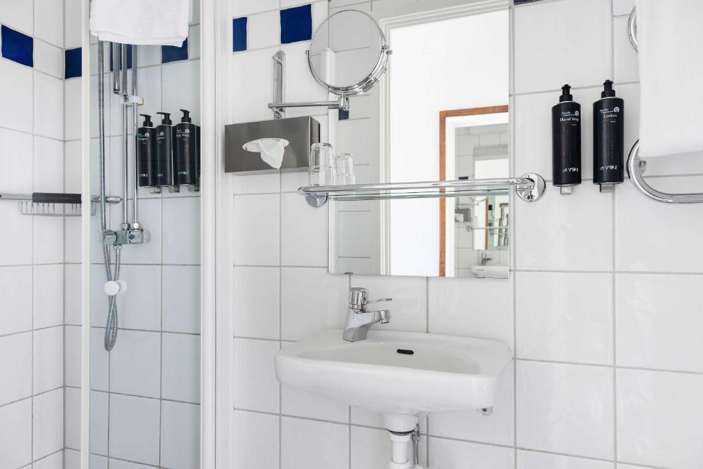 a white bathroom with a sink and a mirror at Best Western Plus Park City Solna in Solna