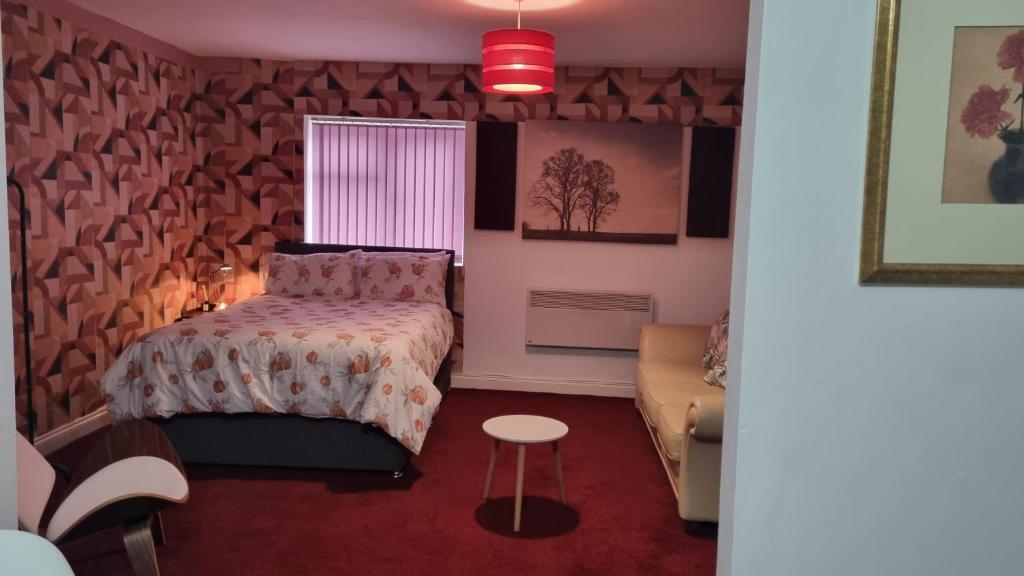 a bedroom with a bed and a couch at Apartment 3 in Leicester