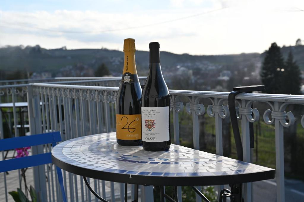 2 bottiglie di vino sedute su un tavolo sul balcone di La Finestra Blu Alba 1 ad Alba