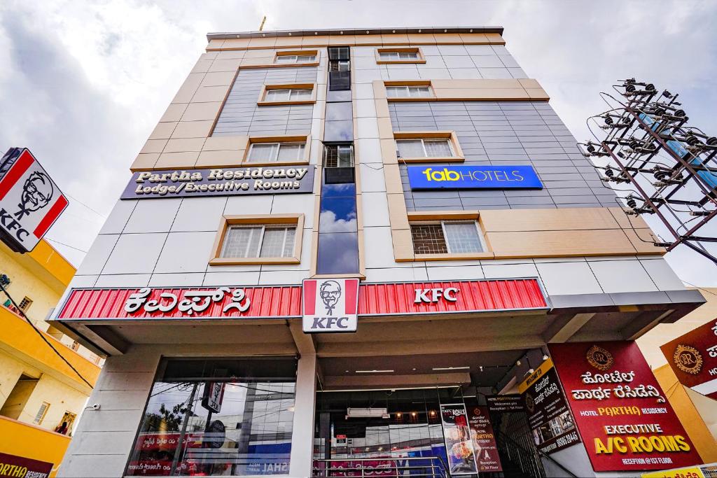 a tall building with a sign on top of it at FabHotel Partha Residency - Kr puram in Bangalore