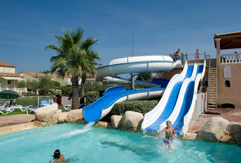 dos personas en una piscina con un tobogán de agua en Domaine Le Clos des Oliviers en Vidauban