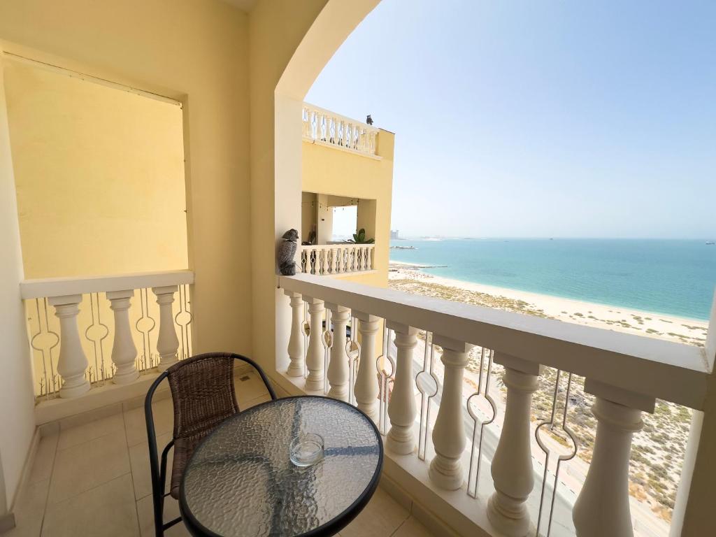 a balcony with a table and a view of the beach at Royal Breeze Sea View One Bedroom Apartment in Ras al Khaimah