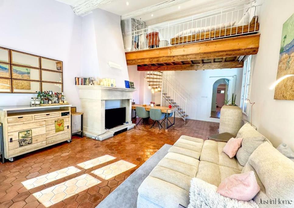 un salon avec un canapé et une cheminée dans l'établissement Magnifique appartement, coeur d'Uzès, clim, à Uzès