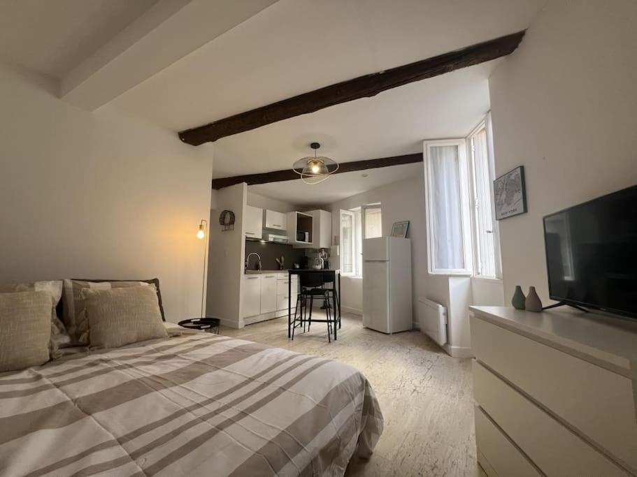 une chambre blanche avec un lit et une cuisine dans l'établissement Studio Cozy Cœur de Ville, à Béziers