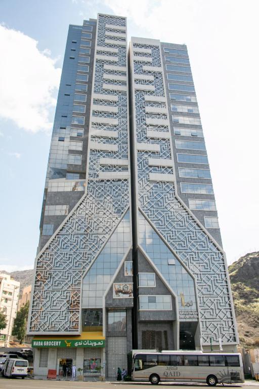 a bus parked in front of a tall building at Lamar Ajyad First Hotel Tower B in Mecca