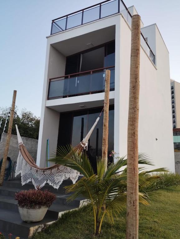a house with a hammock in front of it at Casa de praia do Zeca in Fortaleza