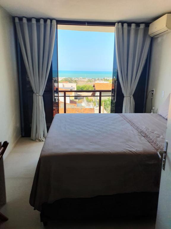 a bedroom with a bed and a large window at Casa de praia do Zeca in Fortaleza