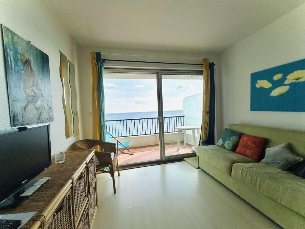 un salon avec un canapé et une vue sur l'océan dans l'établissement Studio en bord de mer avec terrasse, idéal pour 2 personnes - proche commerces et Casino, La Baule - FR-1-245-68, à La Baule